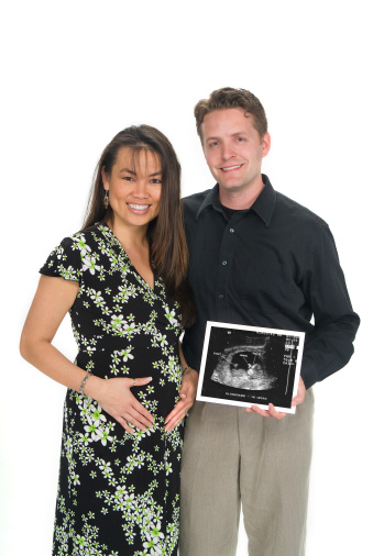 Pregnant couple with ultrasound picture.