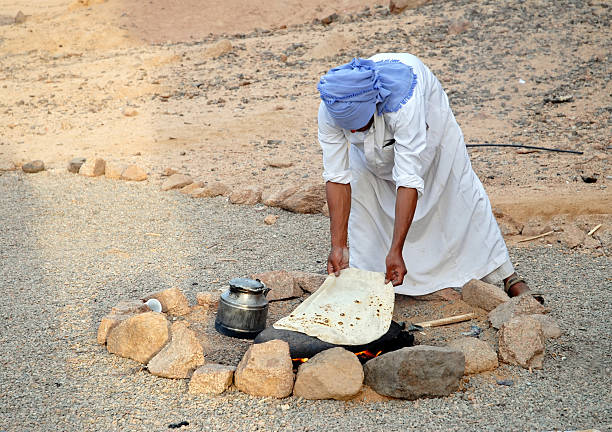 Bedouin baking bread on hot stone, Sinai Desert,Egypt stock photo