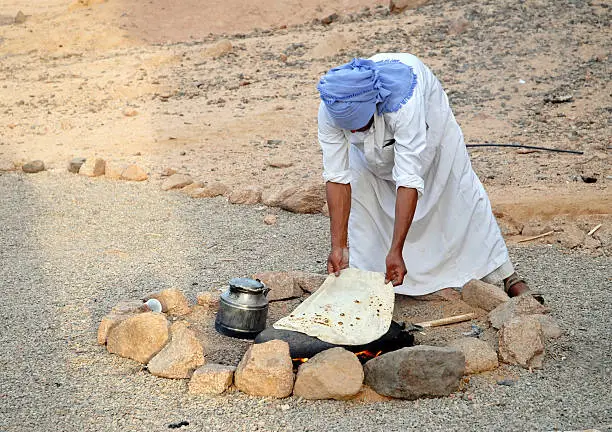 Photo of Bedouin baking bread on hot stone, Sinai Desert,Egypt