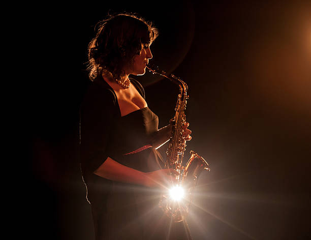 Nightclub music Girl playing saxophone - vintage toning, backlit big band jazz stock pictures, royalty-free photos & images