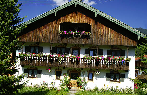 Farm houses on a hill in Upper Bavaria surrounded by blooming meadows on a sunny spring morning in spring, Bavaria, Germany