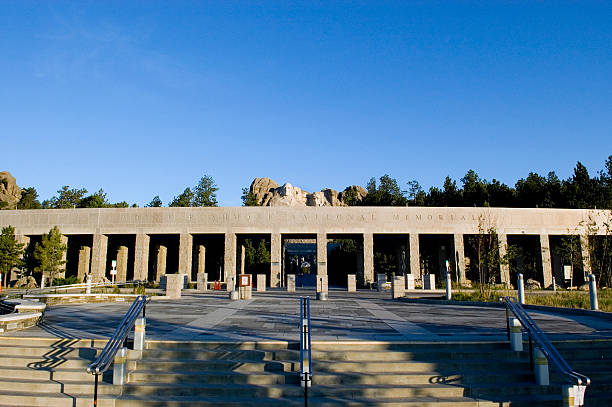 Warm dawn light bathes the main entrance facade at Mt. Rushmore National Monument in South Dakota