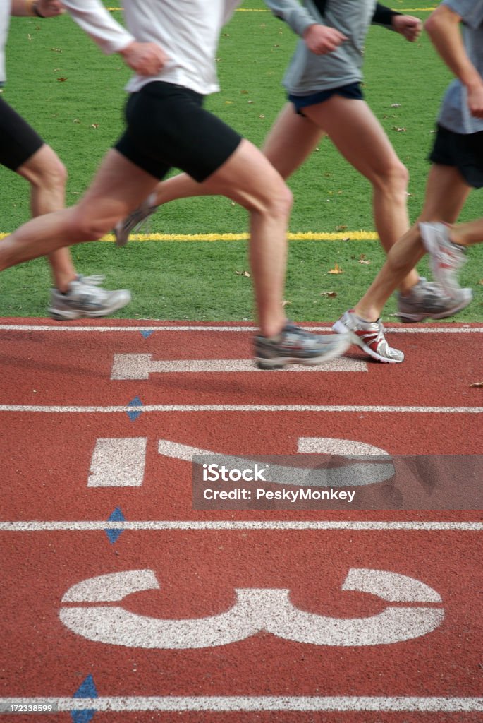 Three, Two, One! A herd of runners sprints down the inside track on the home stretch Number 1 Stock Photo