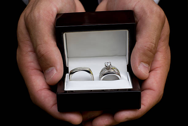 Groom holding wedding rings