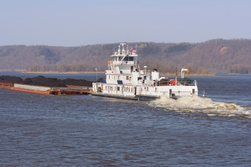 Tug boat on the mississippi with a barge of coal