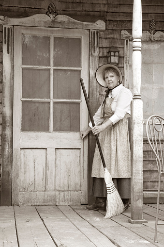 Lady finished sweeping porch