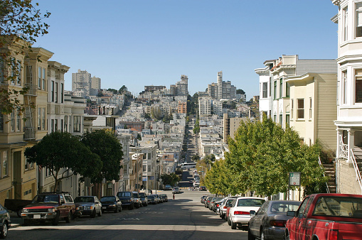 View of street with cars lining homes toward Russian Hill in background, San Francisco, California, USA.