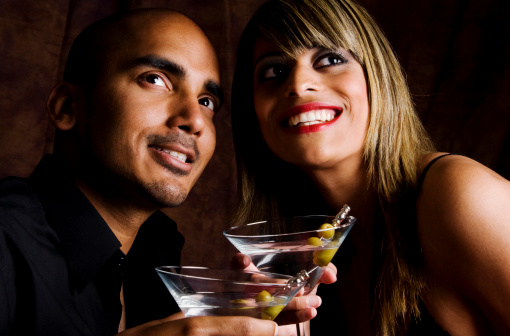 Young couple enjoy a martini during a night out.