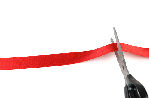 Cutting red tape or ribbon.