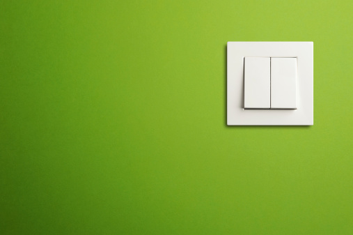 Electric switch in on green wall. Close-up