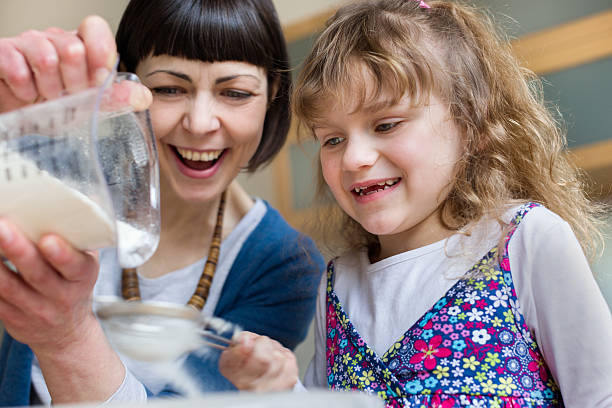 mãe e filha assar um bolo juntos - family germany baking berlin germany - fotografias e filmes do acervo