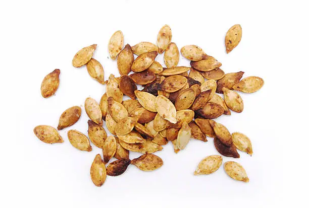 A pile of pumpkin seeds isolated on white