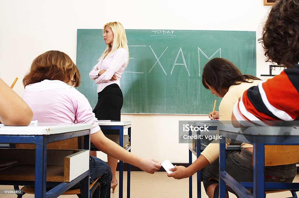 School exam "Two students cheating on exam, teacher looking on other side" Dishonesty Stock Photo