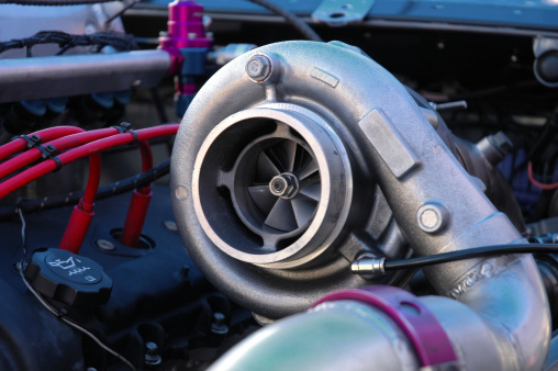 A massive turbocharger on the engine of a race car.