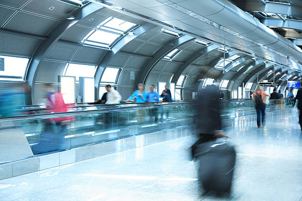 People Walking in Airport Tunnel, Pulling Luggage, Blurred Motion click below to view more related images: airport travelator stock pictures, royalty-free photos & images