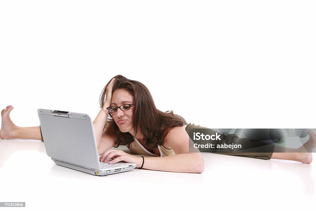 Smirking Woman working on her laptop. Please view all pictures of this 20-24 Years Stock Photo