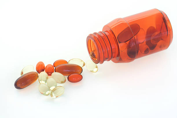 таблетка spill - capsule vitamin pill red lecithin стоковые фото и изображения