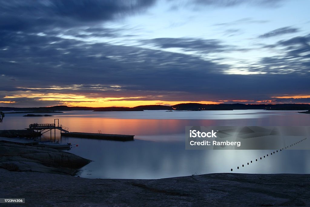 Sunset landscape The last glowing light of the sun stretching above the horizon. Shot on the westcoast of Sweden. Archipelago Stock Photo