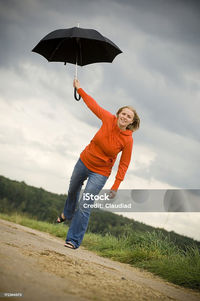 Jumping with umbrella "Blonde girl with umbrella in field, see my other pics:" Dance Floor Stock Photo