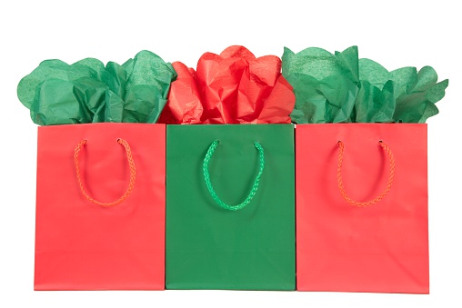 3 red and green gift bags with red and green tissue paper on white background. Christmas image. Ready to put your design or text on. 