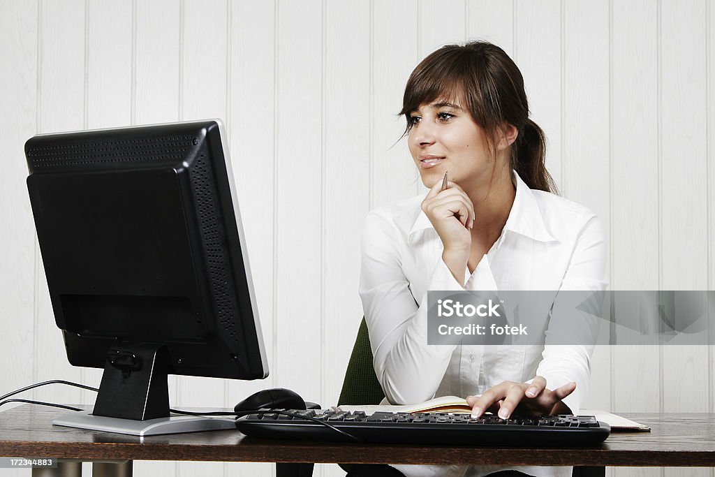 Giovane donna utilizza un computer - Foto stock royalty-free di Adulto