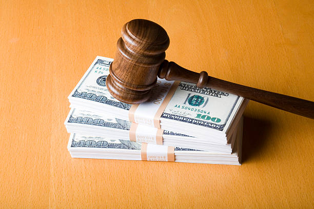 Judge gavel on US dollars Gavel on a stack of 100 dollar bills. Domination stock pictures, royalty-free photos & images