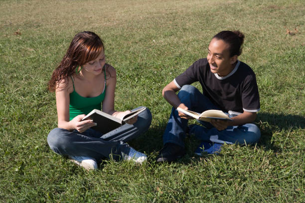 istock Two students sitting on the grass in park 172346575