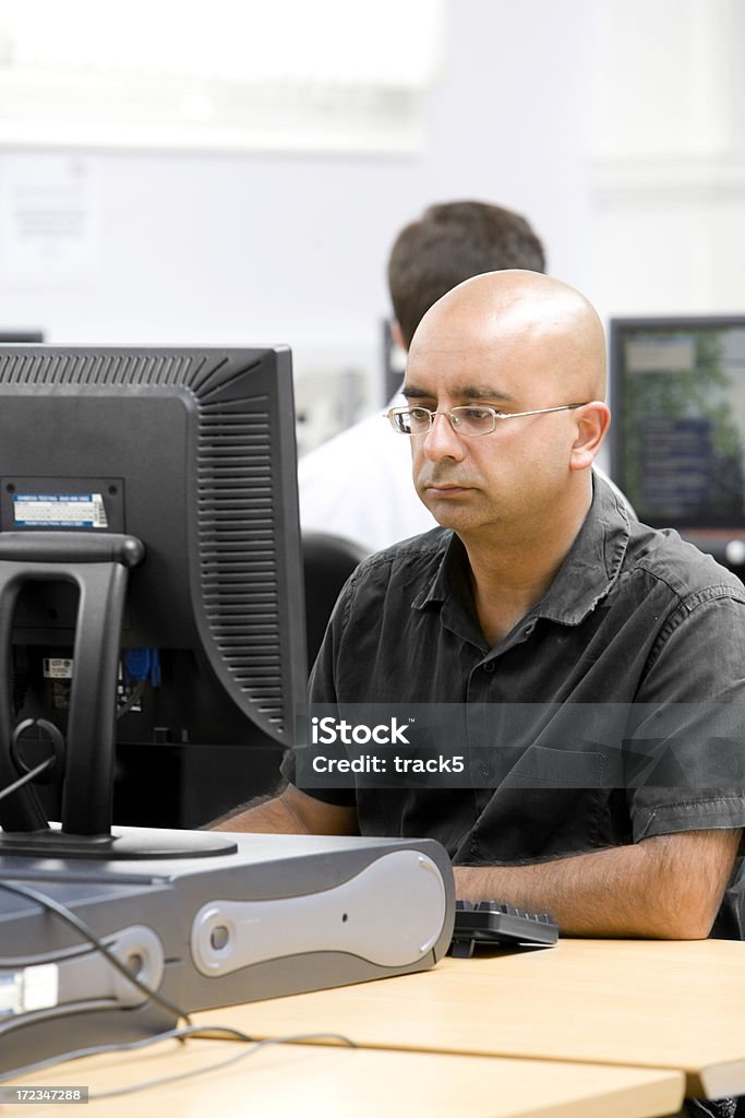 Hombre calvo con gafas mirando a un ordenador - Foto de stock de 30-39 años libre de derechos
