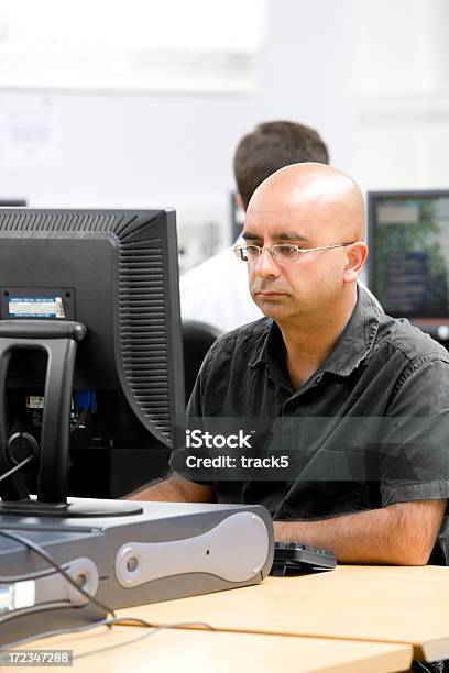 Hombre Calvo Con Gafas Mirando A Un Ordenador Foto de stock y más banco de imágenes de 30-39 años - 30-39 años, 35-39 años, Administrador