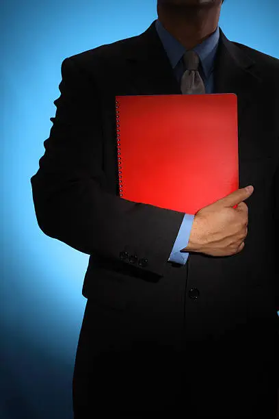 A businessman holding a red document