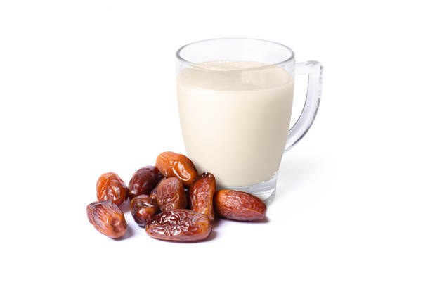 istock Date fruit and glass of milk isolated on white 1723476832