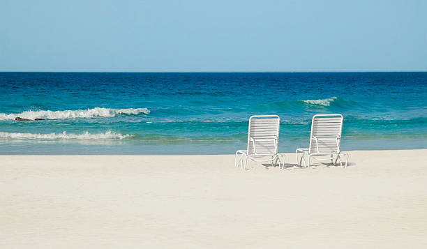 istock Lounge chairs sitting on the sandy beach 172348180