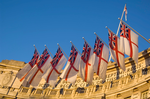 A Bermudan flag waving on a pole in a blue sky