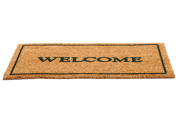 Brown door mat with welcome written across in black