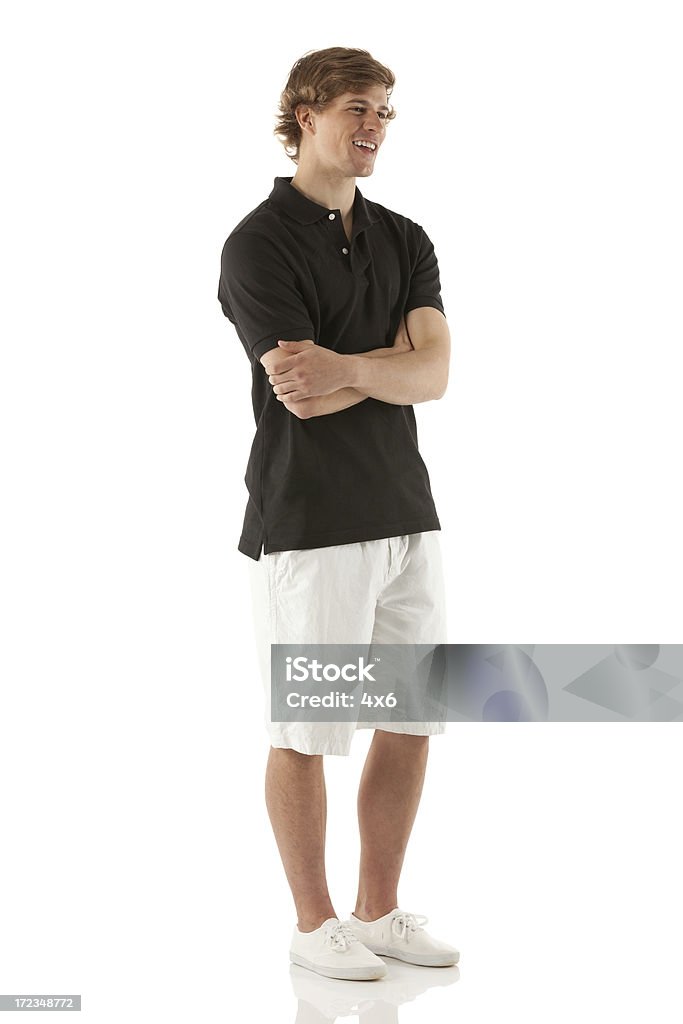 Улыбающийся молодой человек стоя с его руки скрещены - Стоковые фото Красавец роялти-фри
