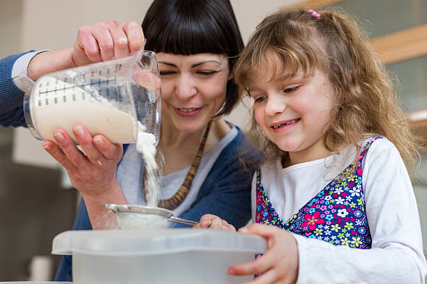 mãe e filha assar um bolo juntos - family germany baking berlin germany - fotografias e filmes do acervo