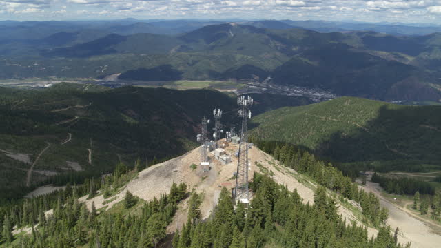Aerial around cell tower in Kellogg Idaho on peak of mountain in summer