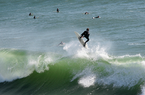 Surfer riding a wave near Lighthouse Field State Beach in Santa Cruz, Ca