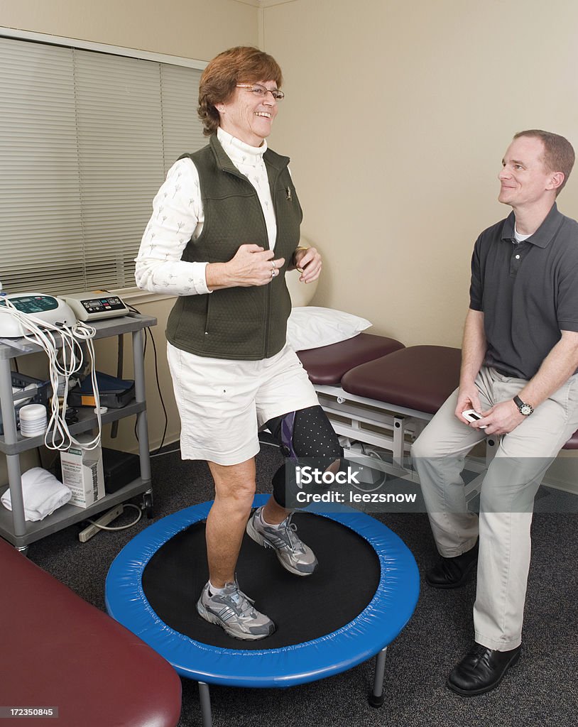 Knee Physical Therapy on Trampoline "Physical therapist timing a knee injury patient exercising on a trampoline.Click below for MORE IN THIS SERIES, plus all of my Physical Therapy and Chiropractic Treatment  images:" Adult Stock Photo