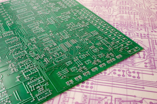 Multilayer printed circuit board on faded original blueprints.Note to Inspector: All design and drawing done by the photographer.