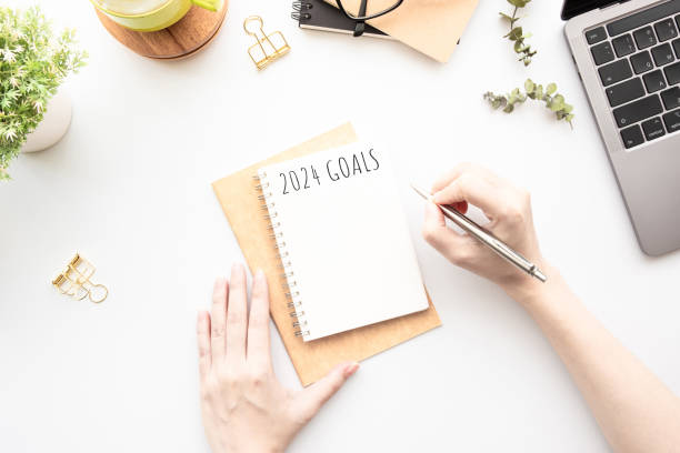 istock Woman is writing 2024 goals for new year resolutions plan. 1723511396