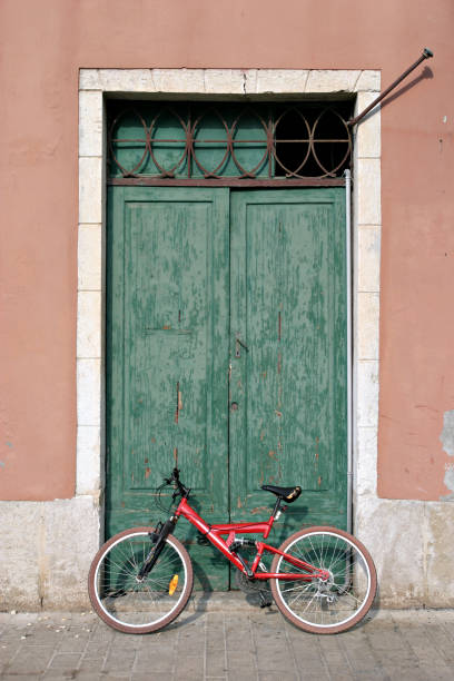 istock red bycicle leaning to an old green portal 172352744
