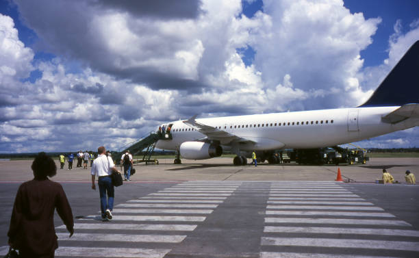 Passengers are seen boarding a flight on the tarmac at Lusaka Airport in Zambia.