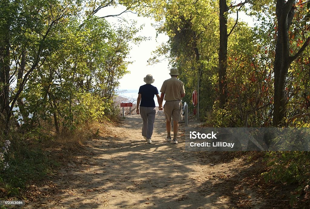 Pareja caminando por ruta agarrar de la mano - Foto de stock de Amor - Sentimiento libre de derechos