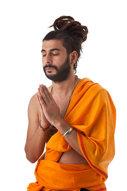 Sadhu at shrine near Uparkot Fort, Junaghad Mullawada, Gujarat, India. Mullawada is a locality within the historic city of Junaghad, renowned for its architecturally significant sites, including temples, step wells and old imperial buildings but also for being one of the most contentious regions during the period of Partition in 1947. Gujarat, the north western state of India,  encompasses part of site of the Indus Valley civilisation, the oldest known to mankind and is also home to some of the most historic sites and religious locations in India. The Rann of Kutch is famous for its arid desert like landscapes as well as wildlife such as the Wild Ass, together with Gir Forest, home to the only Asiatic Lions in the continent.