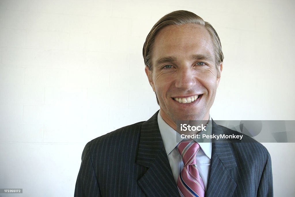 Cheerful Businessman Smiling at Camera White Wall Smiling businessman is happy to meet you Achievement Stock Photo