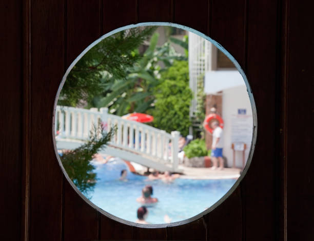 blue pool hinter der hölzerne tür circile fenster - tourist resort large group of people resort swimming pool focus on foreground stock-fotos und bilder