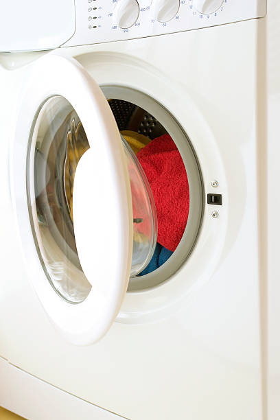 istock Washing machine, opened door, laundry inside, three colorful towels 172355600