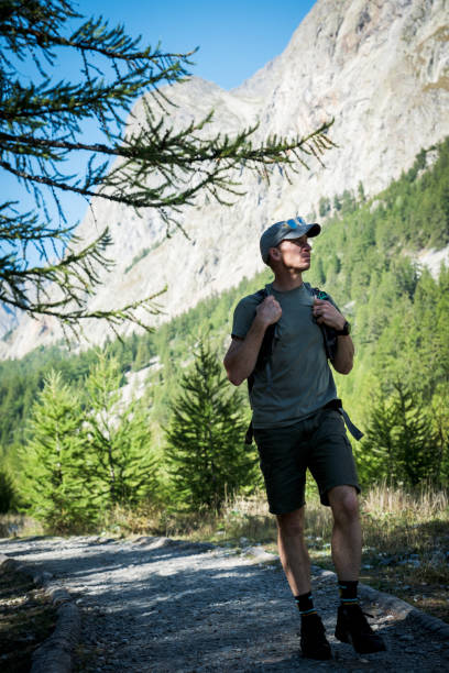 istock Mid adult male with a backpack hiking along a path 1723559527