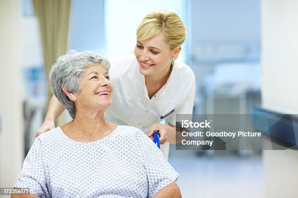 Caring For Her Patients Stock Photo - Download Image Now - Adult, Assistance, Bending Over